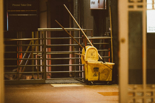 Janitor bucket with cleaning supplies used for commercial office cleaning in a professional workspace