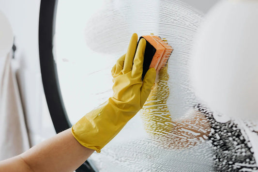 Cleaning services Reno NV professional cleaning a mirror to achieve a spotless, streak-free finish in a commercial workspace